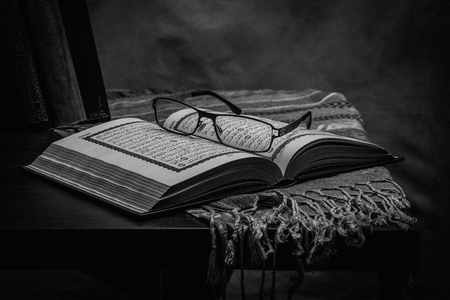 Koran - holy book of Muslims ( public item of all muslims ) on the table , still life . Monochrome or black and white の写真素材