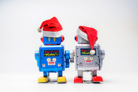 Vintage robot retro classic toy with Christmas hat on white background .