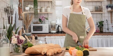 Beautiful young woman cooking in kitchenの写真素材