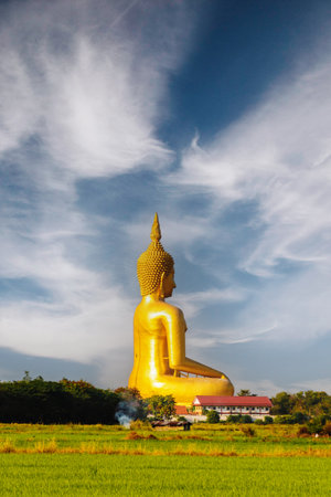 The back of a large golden yellow buddha At Wat Muang, which is an important religious tourist destination In Ang Thong Province in Thailand .の写真素材