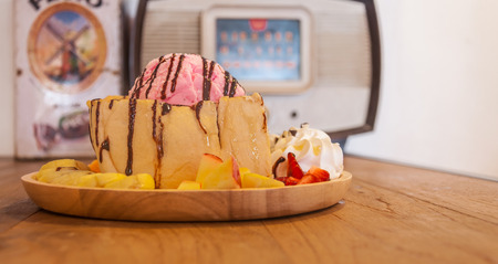honey toast with pink ice cream and fruit on the tableの写真素材