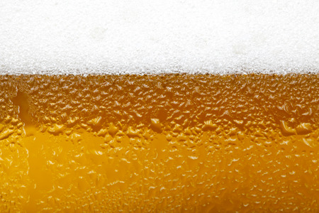 Close-up picture of a beer with foam and bubblesの写真素材