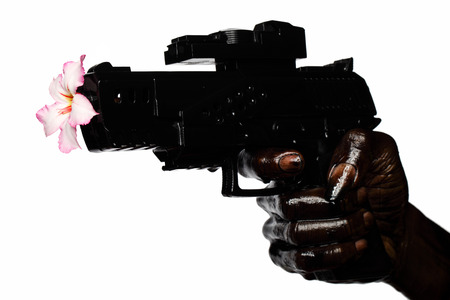 Flower And Gun Held By Hand Stained With Engine Oilの写真素材