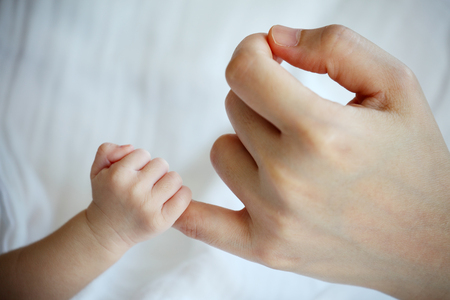 New Born Baby's Hand Gripping Mother's Little Fingerの写真素材
