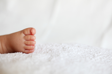 New Born Baby Feet on White Blanketの写真素材