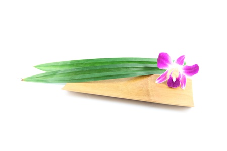 The Purple orchids and pandanus in bamboo dish on the white background.の写真素材