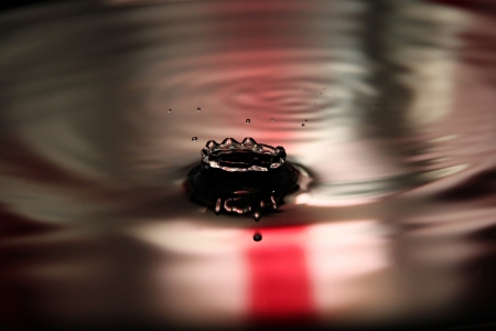 Closeup Pictures Red Background of Water drops a beautiful shape in Basin.の写真素材