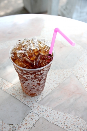 Cola drinks in plastic cup and tube to eat on the table の写真素材