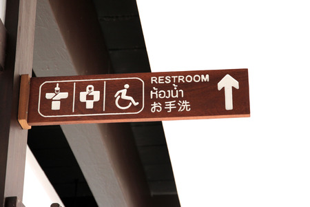 The Wooden sign pointing to the bathroom.の写真素材