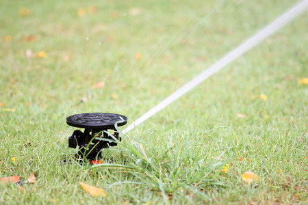 water spread out from the Sprinkler of garden equipment on green grass.の写真素材