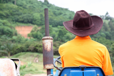 Farmer driving tractor in the rural farm.の写真素材