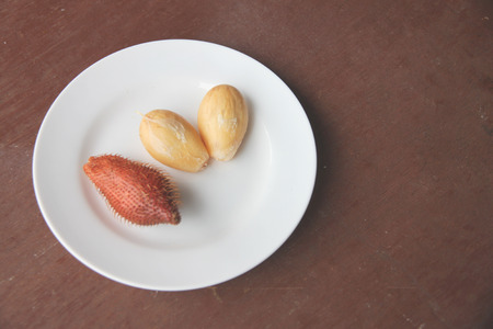 Fresh salacca edulis salak palm fruit of peeling in dish on the foods table.の写真素材