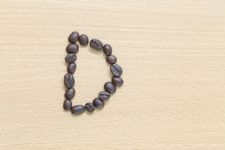 Coffee beans of alphabet placed on the wood .の写真素材