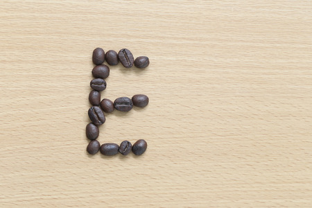 Coffee beans of alphabet placed on the wood .の写真素材