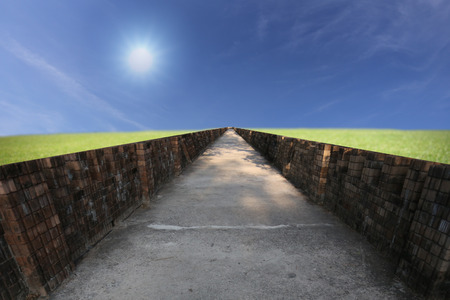 Green grass with pathways stretches on the blue sky.の写真素材