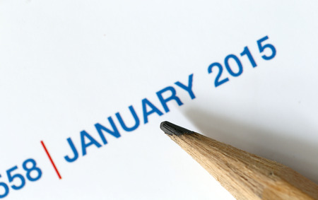 The tip of a pencil point to the year 2015 blur Text on a calendar.