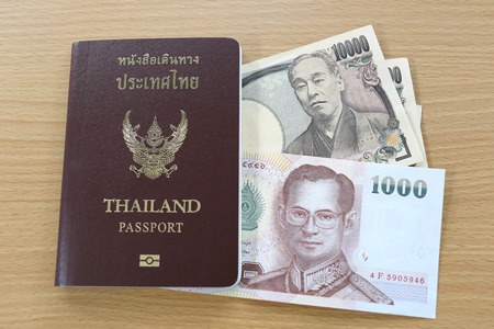 Banknotes of Japan and Thailand in thai passport.の写真素材