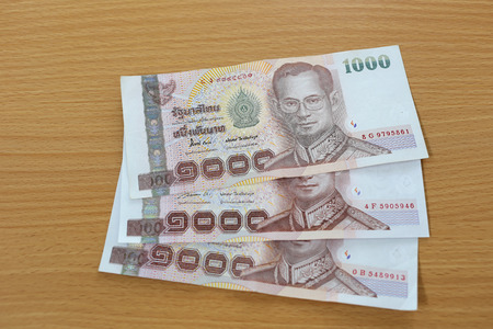 Banknotes of Thailand on wood background.の写真素材