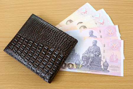 Banknotes of Thailand in wallet on wood background.の写真素材