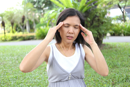 Thai pregnant mom have headache in the garden because of stressful.の写真素材