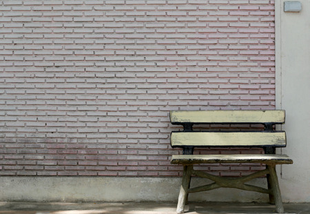 Old bench and a brick wall in the park.の写真素材
