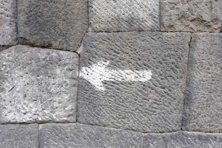 Stacked old stone wall and symbol white arrow for the design background.の写真素材