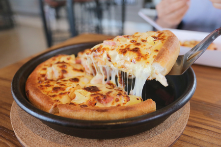 traditional of hot cheese pizza on pan in the restaurant.の写真素材