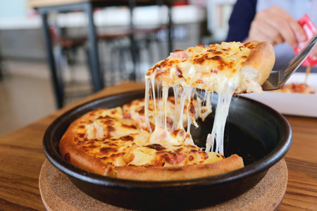 traditional of hot cheese pizza on pan in the restaurant.の写真素材