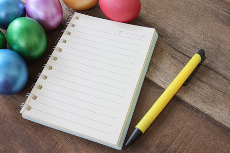 Easter eggs and note book on wood background,Handmade painted for design happy Easter day.の写真素材