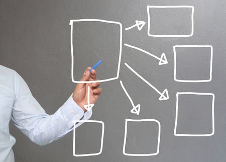 Hand of businessman drawing graphics a symbols geometric shapes graph to input information concept of investment profit in business or management system and have Gray wall of background.の写真素材