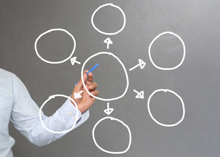 Hand of businessman drawing graphics a symbols geometric shapes graph to input information concept of investment profit in business or management system and have Gray wall of background.の写真素材