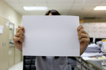 Woman's hand holding a blank white paper for input text to Design Concepts background.の写真素材