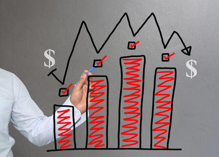 Hand of businessman drawing graphics a top point growing graph to concept of investment profit in business and have Gray wall of background.の写真素材