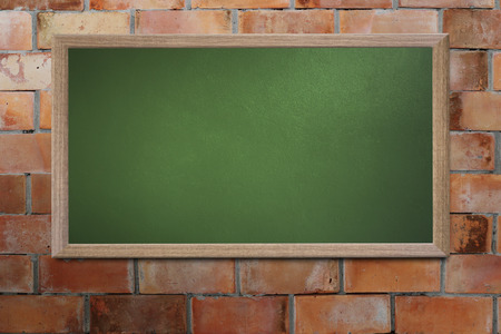 Blank old school blackboard on a grunge wall and can input text or data to wooden frame for concept of education.の写真素材