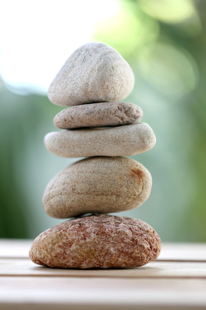 balance rock or zen stones on wooden floor and have nature green background in soft focus.の写真素材