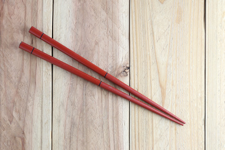 Red chopsticks spoon on wood floor for the design food concept background.の写真素材