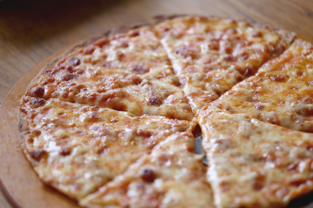 traditional of hot cheese pizza on wooden dish in the restaurant.