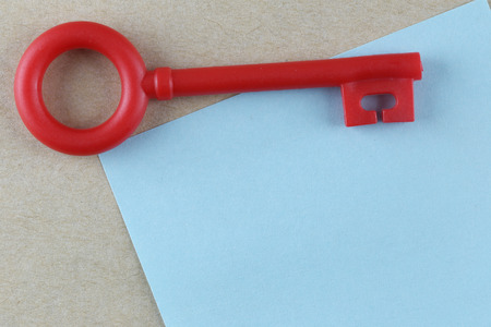 Red Plastic key is placed on Blue Paper Note and can input text to it.の写真素材
