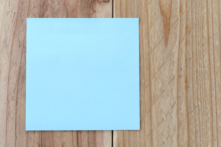 blue paper note on old brown wood background for design and input text.の写真素材