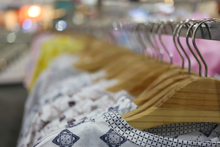 Clothes hang on a shelf in a department store.の写真素材