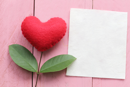 Red heart placed on blue wooden table in connect with branches of tree and have green leaves,concept of love empathy take care and Valentine's Day.の写真素材