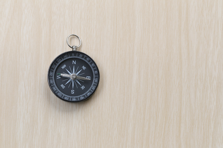 Compass on the brown wooden floor,concept of traveling and trekking.