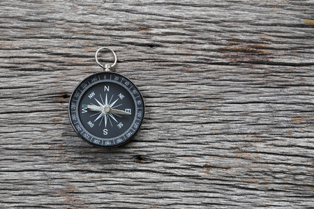 Compass on the brown wooden floor,concept of traveling and trekking.