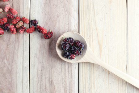 Mulberry fruit in wooden spoon on wood background,concept of healthy tropical fruit.の写真素材