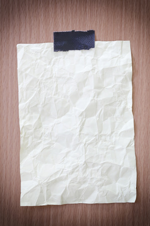 Yellow notepad paper crumpled of empty and copy space on wooden background,You can input the message text in picture.の写真素材