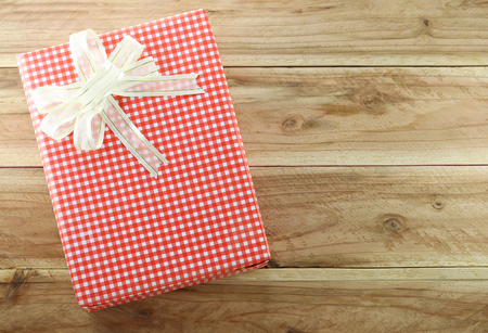 Red gift box on the wooden floor in concept of Christmas and New Year.の写真素材