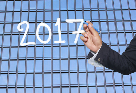 Hand of businessman drawing graphics a text of 2017 in concept of the New Year.の写真素材