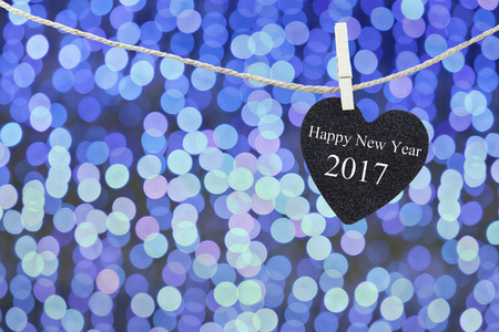 Black Heart hung on hemp rope and blue abstract bokeh background,concept of the New Year 2017.