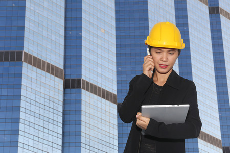 women engineers was on the phone to communicate on Skyscraper background,concept working and construction.の写真素材