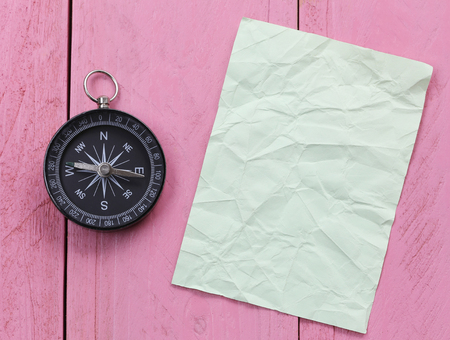 Compass and note paper on the pink wooden floor,concept of traveling and trekking.の写真素材